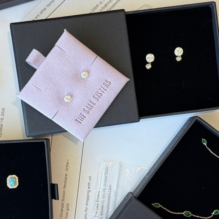 Diamond earrings and an emerald bracelet in The Sale Sisters jewelry boxes and lavender pouch